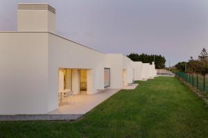 ein weißes Gebäude mit grünem Rasen daneben in der Unterkunft Apartamentos Lobamar in Gijón