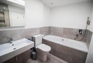 La salle de bains est pourvue de toilettes, d'un lavabo et d'une baignoire. dans l'établissement Serenity "your calm seafront retreat" By Air Premier, à Seaford 12 autres photos