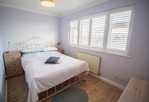 une chambre avec un lit et une fenêtre dans l'établissement Serenity "your calm seafront retreat" By Air Premier, à Seaford