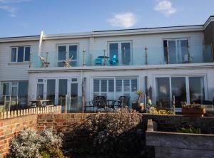 Cette maison blanche dispose de fenêtres et d'une terrasse. dans l'établissement Serenity "your calm seafront retreat" By Air Premier, à Seaford