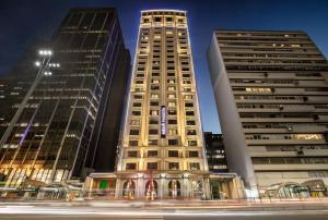 deux grands immeubles dans une ville la nuit dans l'établissement Meliá Paulista, à São Paulo