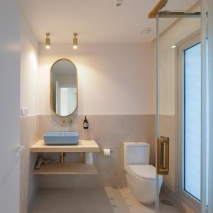 ein Badezimmer mit Waschbecken, Toilette und Spiegel in der Unterkunft Apartamentos Lobamar in Gijón + 47 Fotos