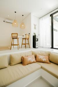a living room with a couch with pillows on it at Villas Tamu 1 in Bingin Beach