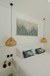 a white bedroom with two lamps and a bed at Villas Tamu 1 in Bingin Beach +23 photos