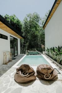 a swimming pool with two bean bags on the ground at Villas Tamu 1 in Bingin Beach