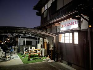 ein Schild an der Seite eines Gebäudes mit einem Tisch in der Unterkunft Cornell Airport Station Pickup Dropoff in Kishiwada