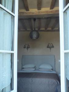 Cama en habitación con ventana y lámpara en Gîte de charme Floréales Les Iris, en Asnelles