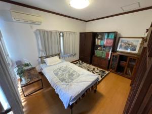 ein Schlafzimmer mit einem Bett und einem Bücherregal in der Unterkunft Cornell Airport Station Pickup Dropoff in Kishiwada