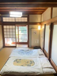 ein Schlafzimmer mit einem großen Bett in einem Zimmer mit Fenstern in der Unterkunft Cornell Airport Station Pickup Dropoff in Kishiwada