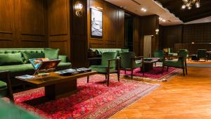 een wachtkamer met groen meubilair en tafels en stoelen bij Liv Hotels Erciyes in Cebir