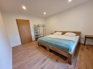 a bedroom with a bed and a wooden floor at Reload Apartments - FeWo3 im Remmeker Feld in Bad Arolsen