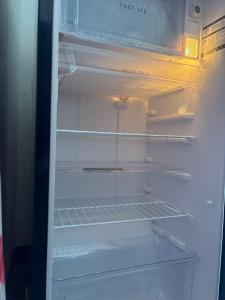 an empty refrigerator with its door open and its shelves at De beachside Villa in Virāmpattinam