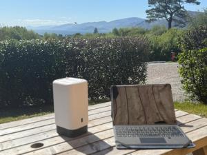 a laptop computer sitting on a table next to a speaker at 1 Bedroom Cabin with Mountain & Loch Views - Quiet Location between Glencoe & Ben Nevis in Onich +24 photos