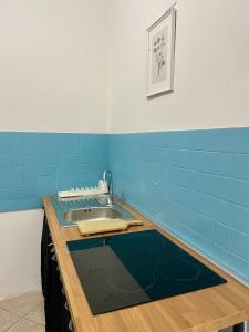 a kitchen with a sink and blue tiles at Carioca Aparthotel in Capua