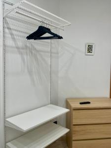 a closet with white shelves and a blue jacket at Carioca Aparthotel in Capua +13 photos
