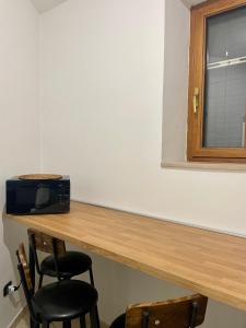 a room with a counter with two chairs and a microwave at Carioca Aparthotel in Capua