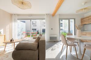 a living room with a couch and a table at Jolie maison de style bohème, douce et lumineuse in Bordeaux
