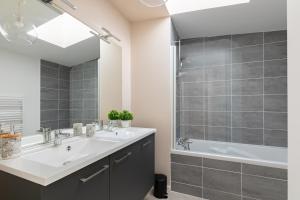 a bathroom with a sink and a shower and a tub at Jolie maison de style bohème, douce et lumineuse in Bordeaux