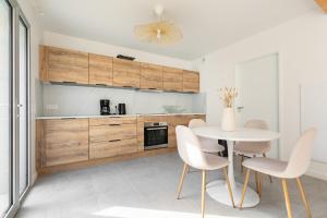 a kitchen with a table and white chairs at Jolie maison de style bohème, douce et lumineuse in Bordeaux +2 photos
