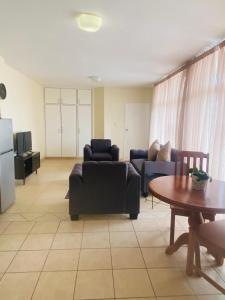ein Wohnzimmer mit zwei Sofas und einem Tisch in der Unterkunft The Oceanic 1 bedroom apartment - Self Catering in Durban