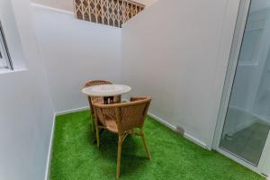 a room with a table and a chair and green carpet at Secrets Torrevieja in Torrevieja
