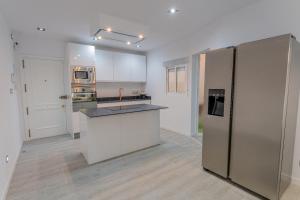 a kitchen with white cabinets and a stainless steel refrigerator at Secrets Torrevieja in Torrevieja