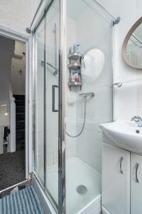 Russel Square Rooms في لندن: حمام مع دش ومغسلة