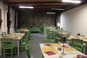 a dining room with tables and green chairs at Batteria Chiodo rifugio escursionistico e culturale in Monte Marcello
