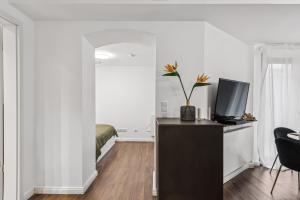 a room with a desk with a television and a bed at Arbio I Stylish Apart Schöneberg S-Bahn in Berlin