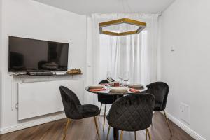 a dining room with a black table and chairs at Arbio I Stylish Apart Schöneberg S-Bahn in Berlin
