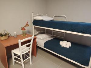 a room with two bunk beds and a desk and a chair at Batteria Chiodo rifugio escursionistico e culturale in Monte Marcello