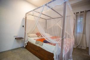 una cama con dosel en una habitación en Mealanie's House, en Unawatuna