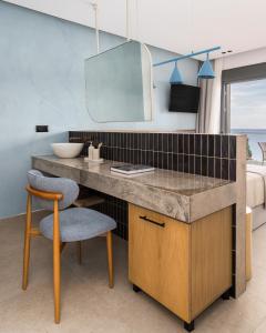 a bathroom with a desk and a chair and a mirror at Orizon Boutique Rooms in Kalamitsi
