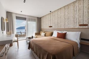 a hotel room with a large bed and a couch at Orizon Boutique Rooms in Kalamitsi