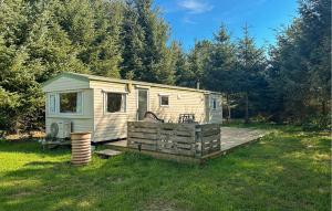 une petite remorque blanche posée sur une terrasse en bois dans l'établissement 3 Bedroom Nice Home In Nexø, à Balke