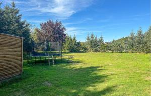 une cour avec un filet dans l'herbe dans l'établissement 3 Bedroom Nice Home In Nexø, à Balke