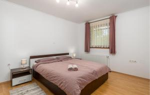a bedroom with a bed with two white shoes on it at Amazing Apartment In Vrbovsko With Sauna in Vrbovsko