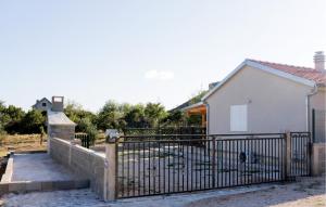 een hek voor een wit huis bij Awesome Home In Lisane Ostrovicke With Wifi in Lišane Ostrovičke