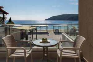 a table and chairs on a balcony with a view of the ocean at Orizon Boutique Rooms in Kalamitsi