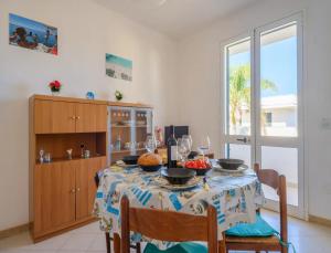 ein Esszimmer mit Tisch und Stühlen und einem Fenster in der Unterkunft Coral Bay House in Torre dell'Orso + 21 Fotos