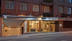 una tienda con puertas de cristal en una calle en NH Bilbao Deusto, en Bilbao