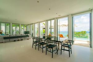 a dining room with a table and chairs and the ocean at Surin Heights Villa in Surin Beach
