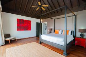 a bedroom with a bed and a ceiling fan at Surin Heights Villa in Surin Beach