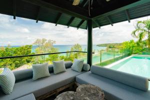 a room with a couch and a swimming pool at Surin Heights Villa in Surin Beach +36 photos