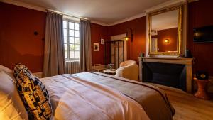 a bedroom with a bed and a fireplace and a mirror at Le Prieuré d'Arbois in Arbois
