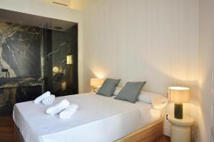 a bedroom with a white bed with towels on it at Antonia Luxury Home in Seville