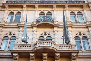 a building with two flags on the side of it at Miiro Palais Rudolf in Vienna +70 photos