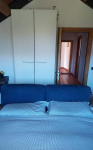 un lit dans une chambre avec un canapé bleu dans l'établissement Camere per Olimpiadi di Cortina 2026, à Col