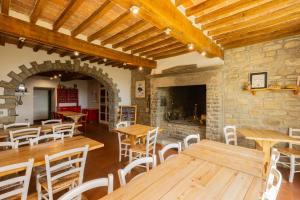 a restaurant with wooden tables and chairs and a fireplace at Fattoria di Germagnano in Sansepolcro