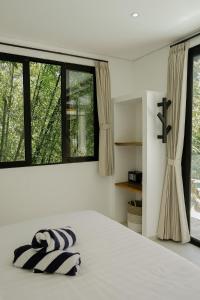 a bedroom with a bed and a large window at Villas Tamu 4 in Bingin Beach